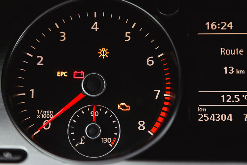 Dashboard warning lights showing a car may need service soon.